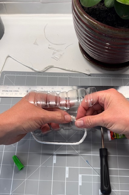 Attaching pull-strings to a homemade dressing device to assist with putting on socks.