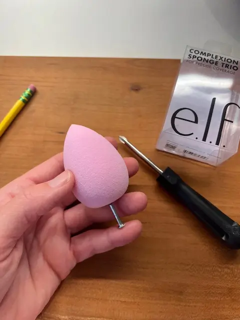 step #1 of step by step instructions: (push a thin nail end to end through the thick end of the beauty blender to the opposite then end, slowly.
