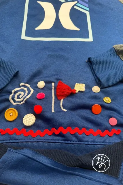 A close-up shot showing exactly how a fidget tool is sewn or attached to the fabric, demonstrating the "Step-by-Step" nature of the tutorial.